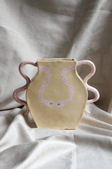 Een beige vaas met twee roze handvatten en een decoratief patroon.