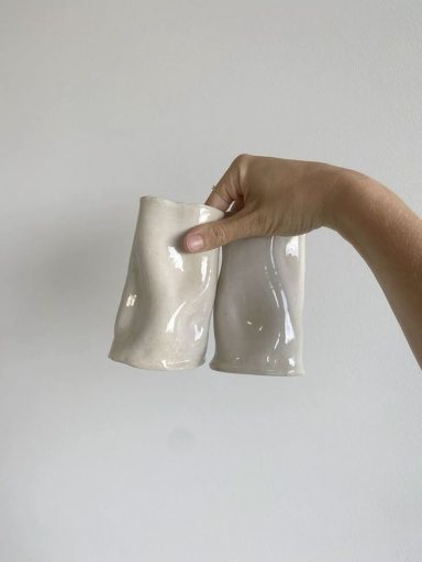 Hand houdt twee keramische bekers vast