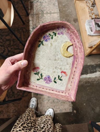 Handgemaakte altaartje met bloemen en een halve maan aan de binnenkant.