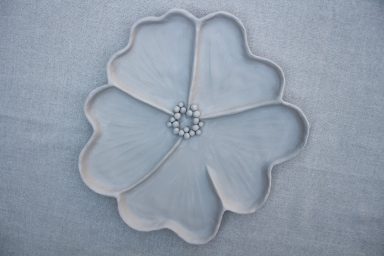 Decoratieve schotel in de vorm van een bloem met een stralend middenstuk.