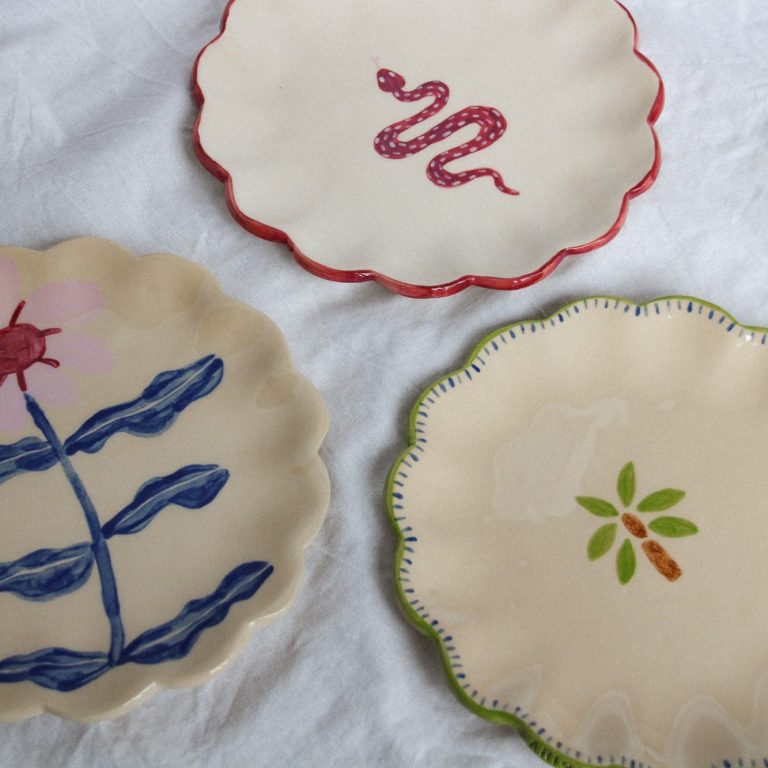 Drie beschilderde borden met verschillende ontwerpen en kleuren.